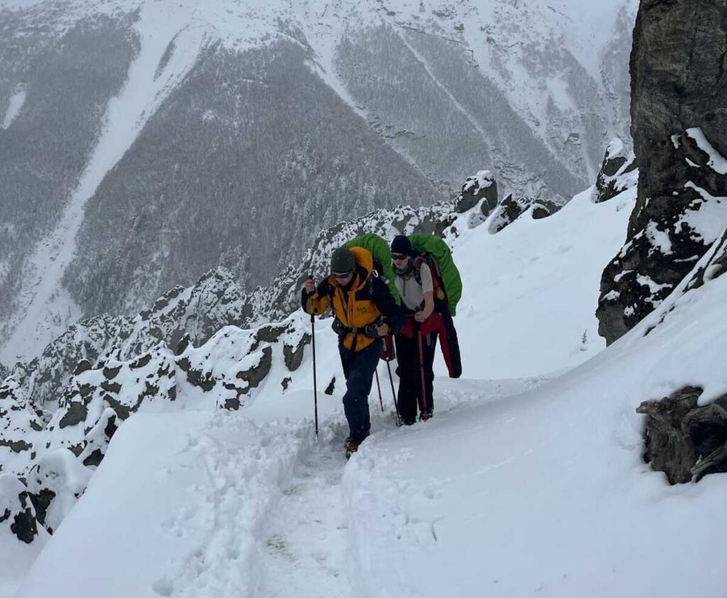 trekkers crossing the snowy Thorong La Pass during the Annapurna Circuit Trek in Nepal.
