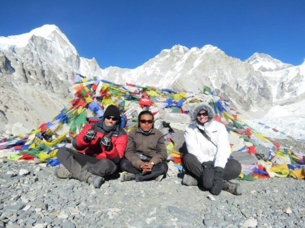 Three trekkers posing at Everest Base Camp