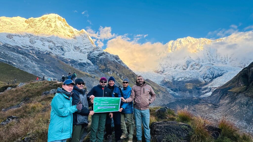 Trekkers holding a Create Himalaya banner at Annapurna Base Camp.