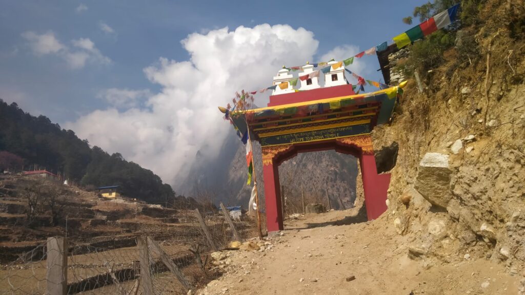 Pungen Gompa gate with Buddhist prayer flags on the Manaslu trekking trail.